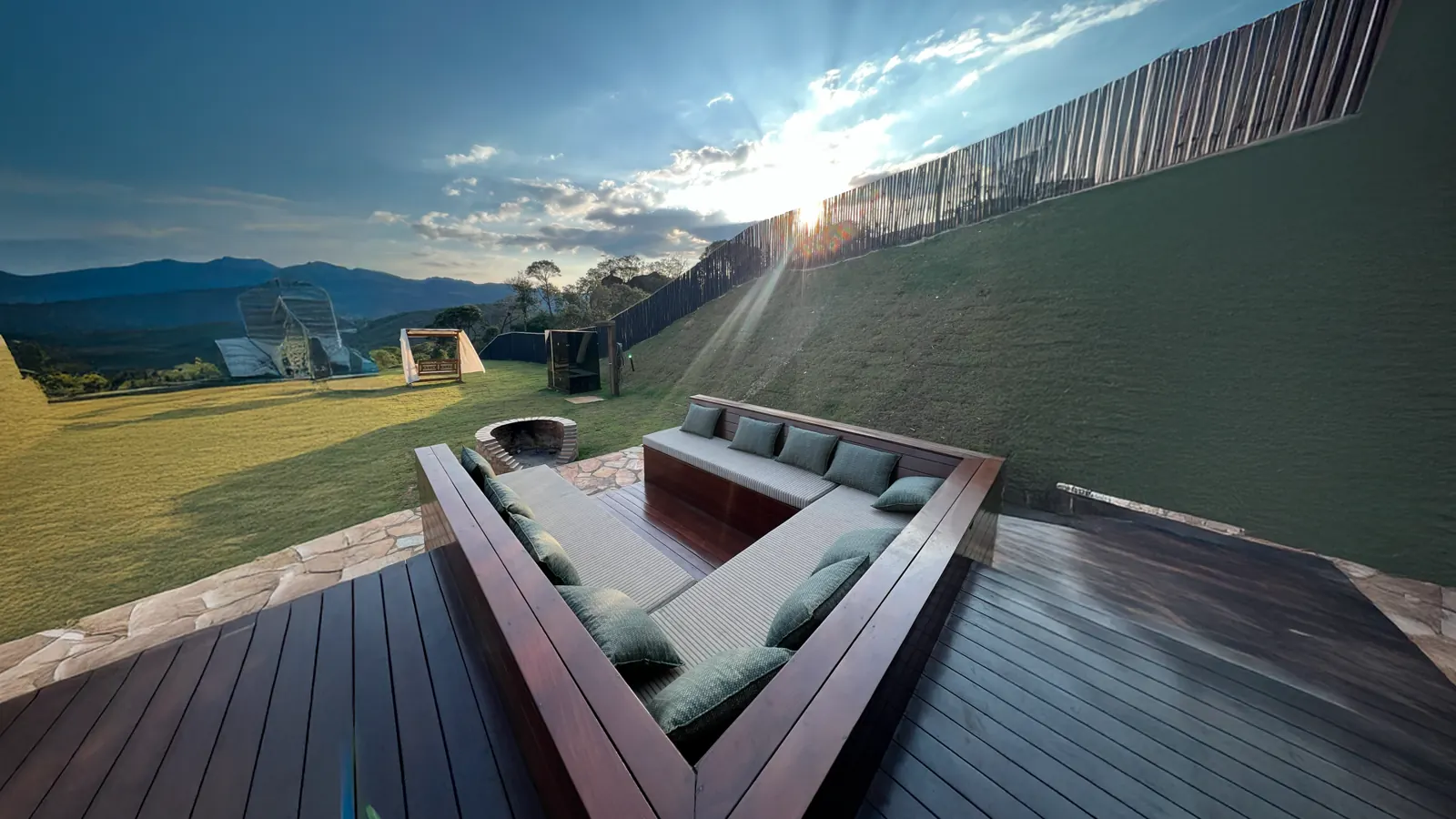 Lounge externo com fire pit e montanhas ao fundo